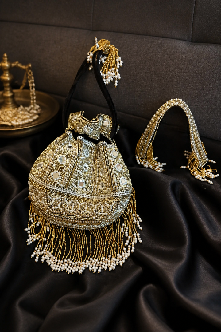 Luxury handcrafted potli bag with mirror embellishments, pearl detailing, embroidery, and elegant tassel fringe design