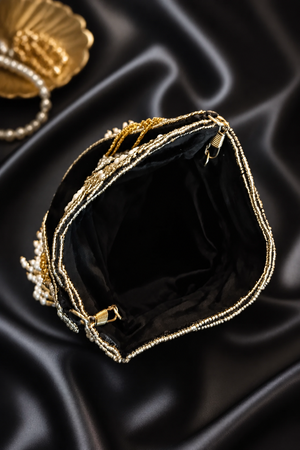 Luxury handcrafted potli bag with mirror embellishments, pearl detailing, embroidery, and elegant tassel fringe design