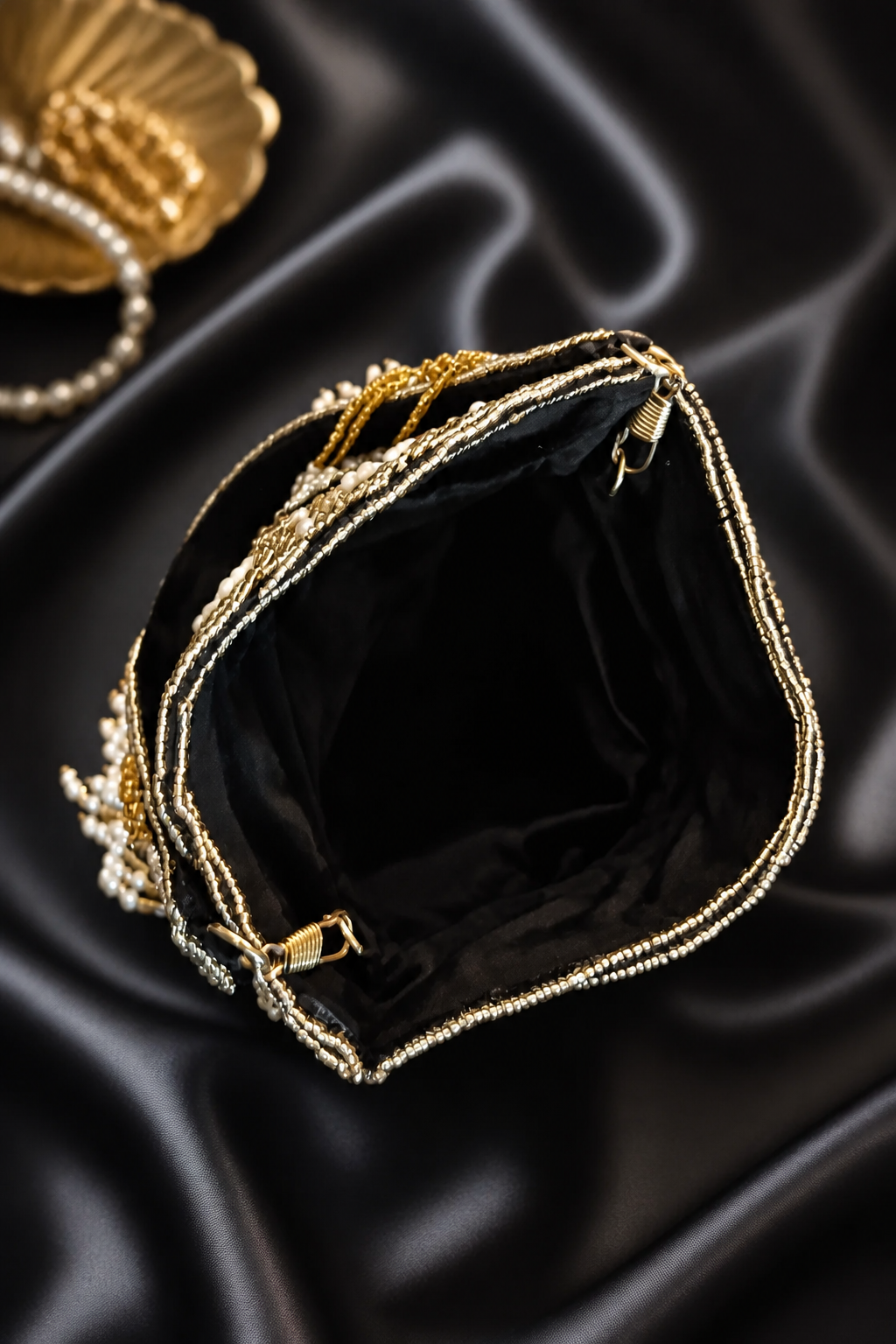 Luxury handcrafted potli bag with mirror embellishments, pearl detailing, embroidery, and elegant tassel fringe design
