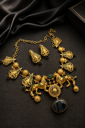 Antique gold lion motif statement necklace with black onyx stone pendant, intricate filigree detailing, and matching designer earrings on a black background