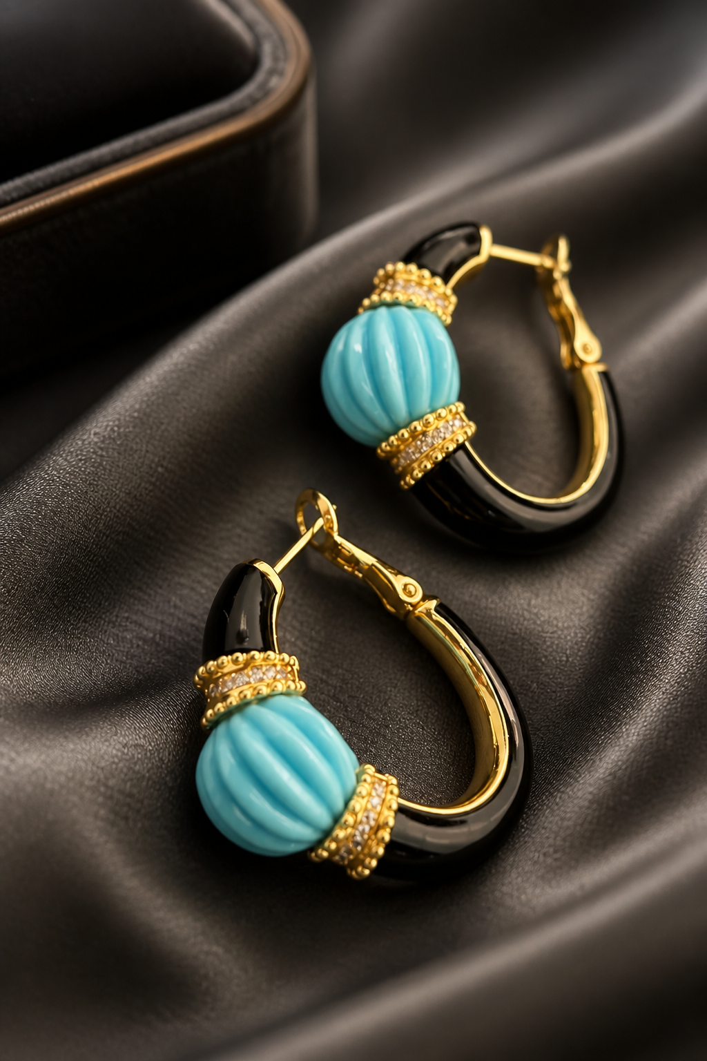 Earring with carved stone with black enamel