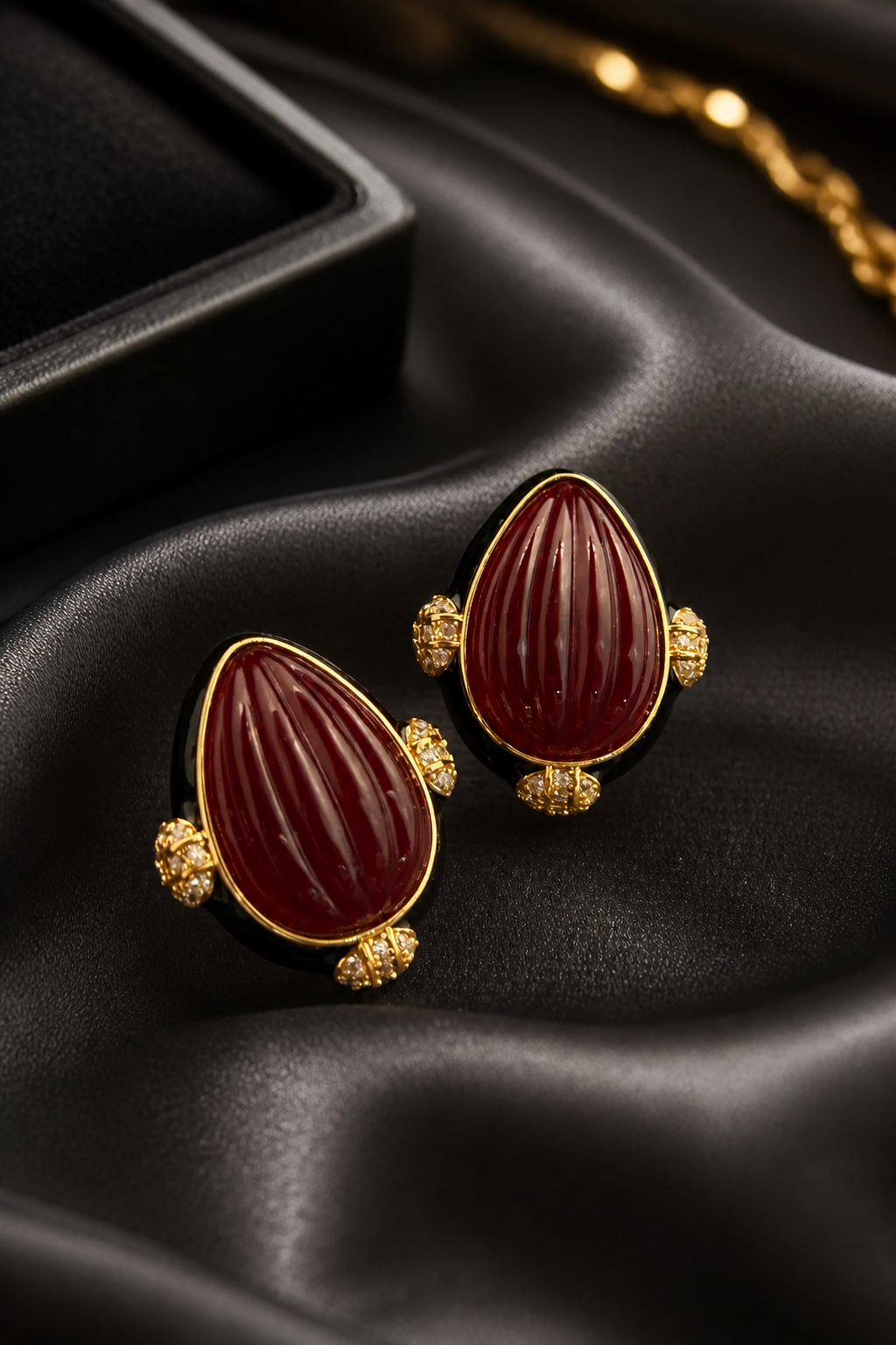 Earring with carved stone with black enamel