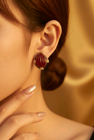 Earring with carved stone with black enamel