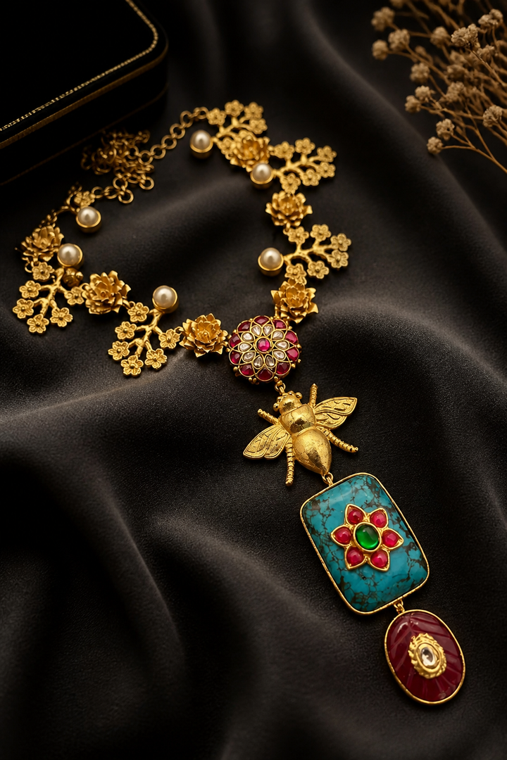 Designer bug motif necklace with turquoise pendant and intricate gold detailing in artistic ethnic jewellery style