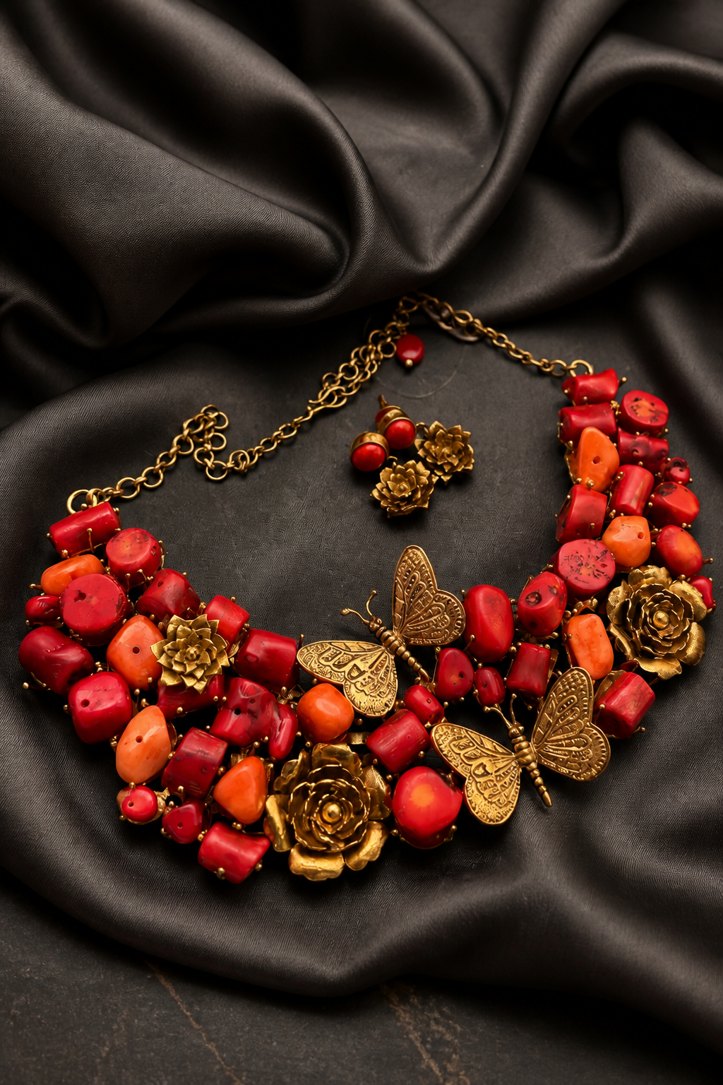 Statement coral tumble necklace with butterfly charms, floral motifs, and antique gold detailing with matching earrings