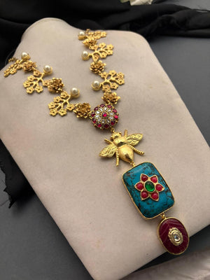 Designer bug motif necklace with turquoise pendant and intricate gold detailing in artistic ethnic jewellery style