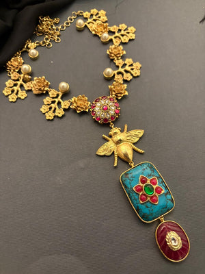 Designer bug motif necklace with turquoise pendant and intricate gold detailing in artistic ethnic jewellery style