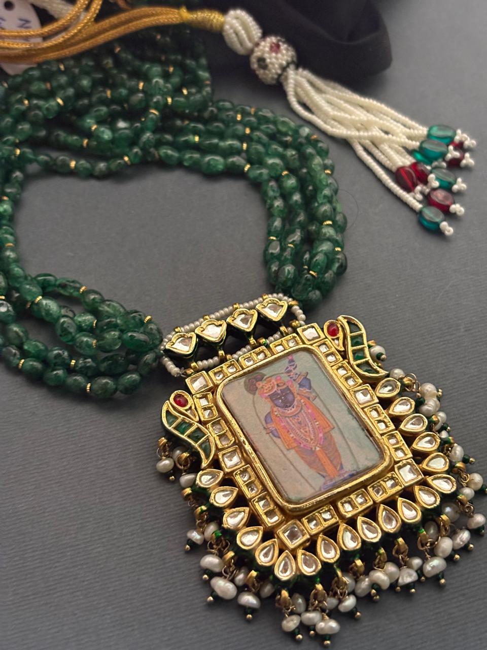 Miniature painting necklace with Shrinath Ji artwork, kundan crystal detailing, and green aventurine bead strands in traditional ethnic style
