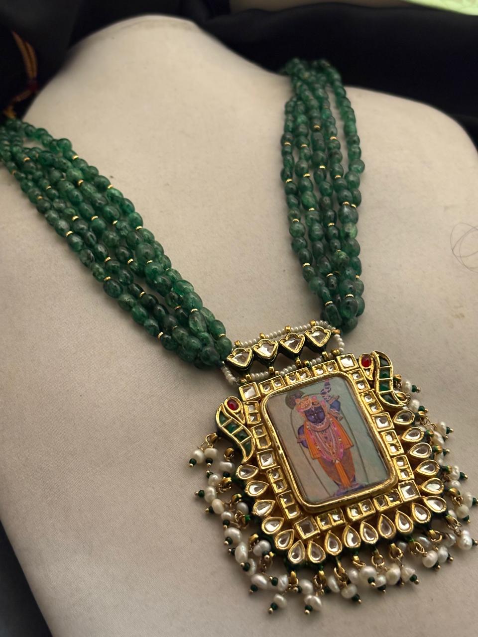 Miniature painting necklace with Shrinath Ji artwork, kundan crystal detailing, and green aventurine bead strands in traditional ethnic style