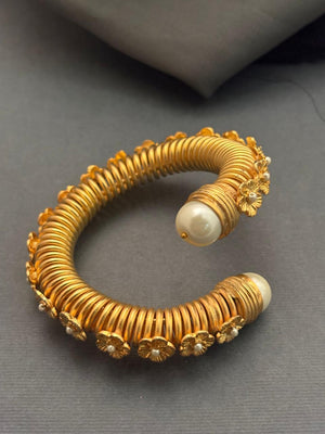 Elegant gold textured bracelet with shell pearl detailing in traditional ethnic designer style