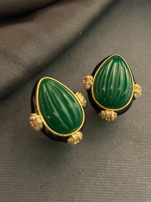 Designer earrings with carved green stones and black enamel detailing in elegant ethnic style