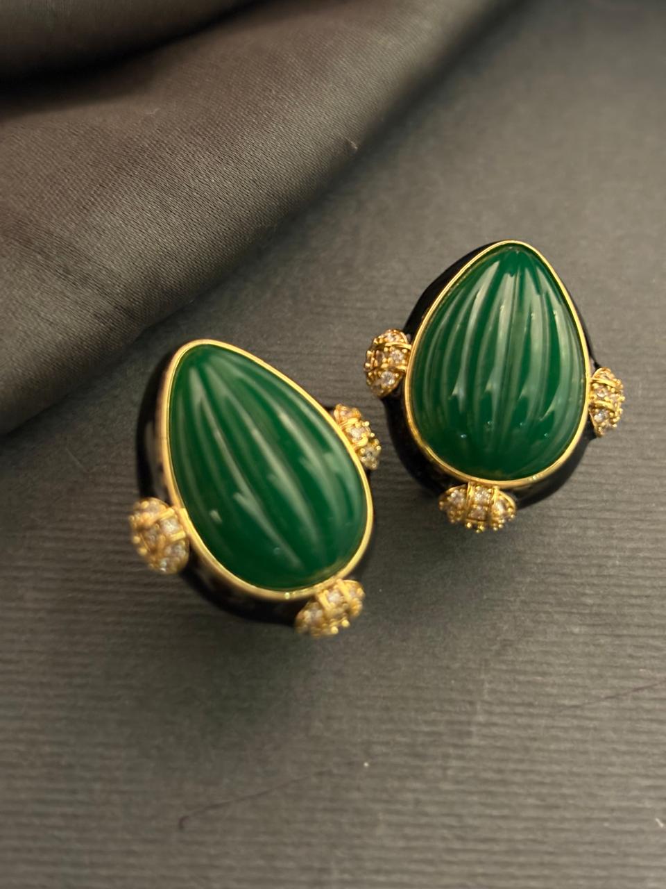 Designer earrings with carved green stones and black enamel detailing in elegant ethnic style