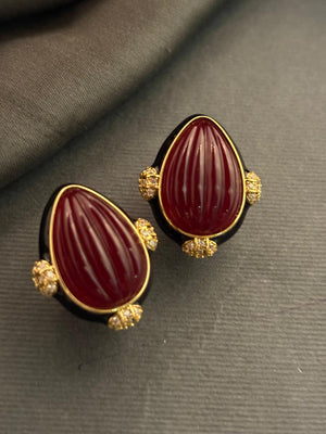 Designer earrings with carved red stones and black enamel detailing in elegant ethnic style