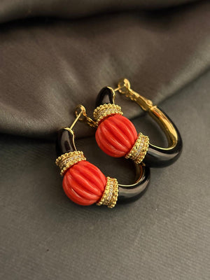 Designer earrings with carved red stones and black enamel detailing in contemporary ethnic style
