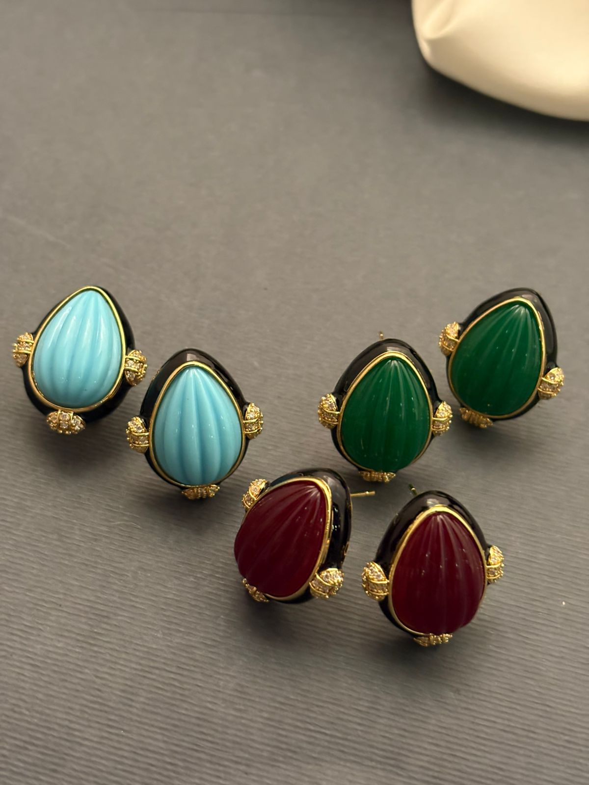 Earring with carved stone with black enamel