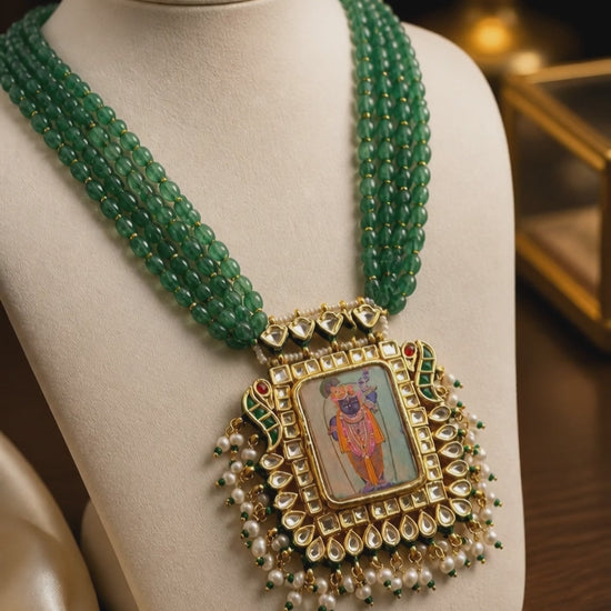 Miniature painting necklace with Shrinath Ji artwork, kundan crystal detailing, and green aventurine bead strands in traditional ethnic style