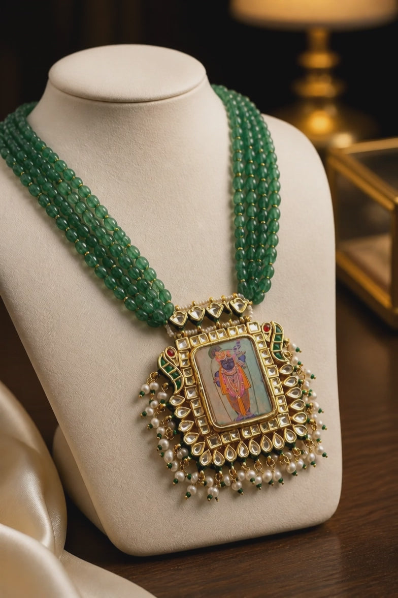 Miniature painting necklace with Shrinath Ji artwork, kundan crystal detailing, and green aventurine bead strands in traditional ethnic style