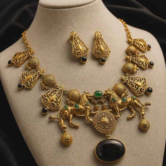 Antique gold lion motif statement necklace with black onyx stone pendant, intricate filigree detailing, and matching designer earrings on a black background
