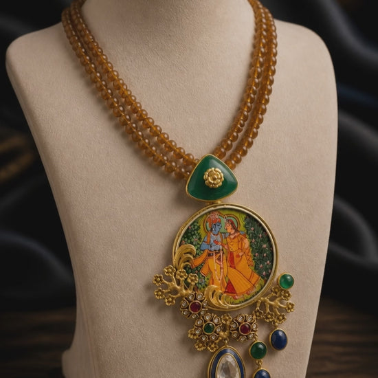 Miniature painting necklace with Radha Krishna artwork, kundan crystal detailing, and brown bead strands in traditional ethnic jewellery style