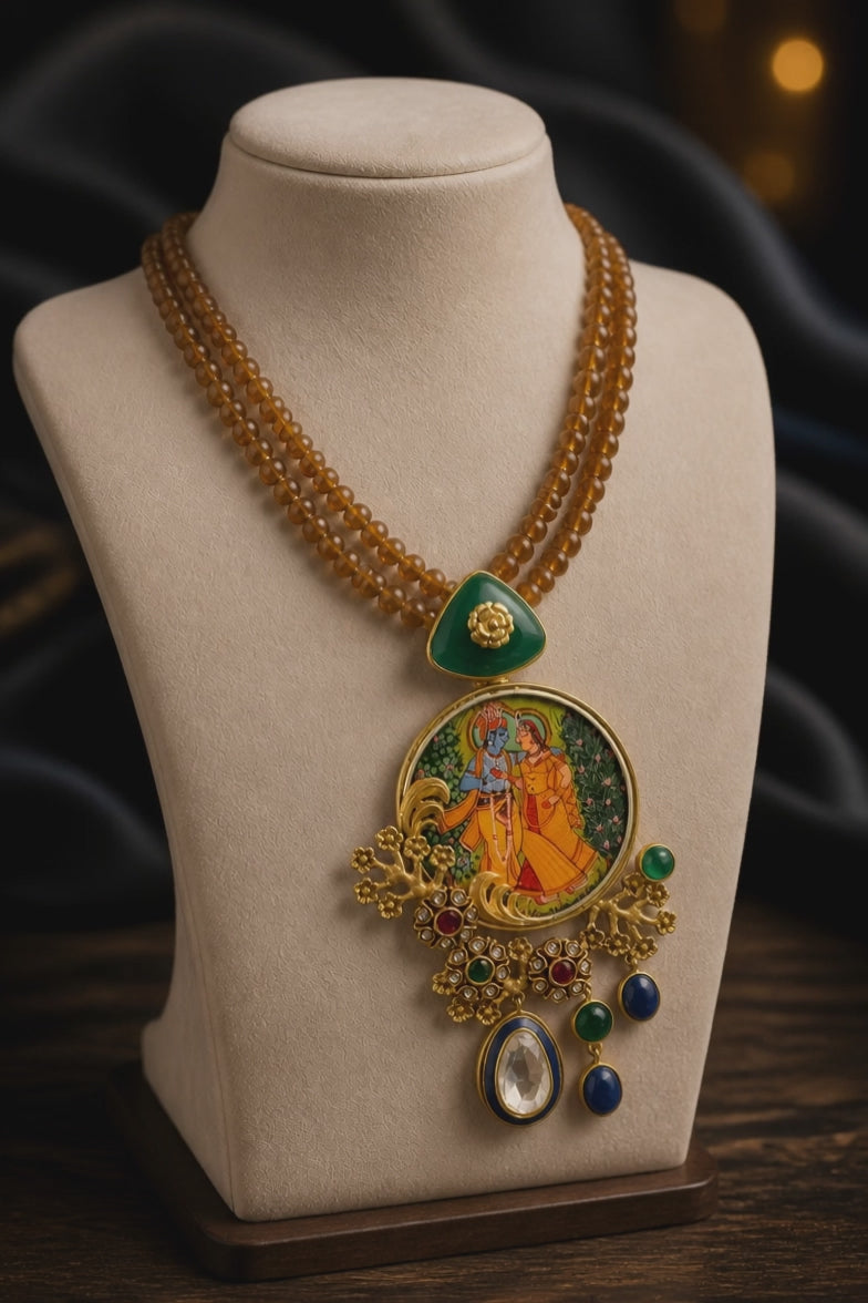 Miniature painting necklace with Radha Krishna artwork, kundan crystal detailing, and brown bead strands in traditional ethnic jewellery style