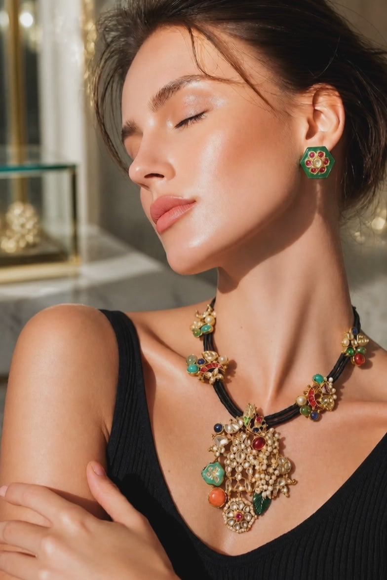Black cord statement necklace with multicolor stones, jadau motifs, pearl detailing, and matching stud earrings in antique gold finish